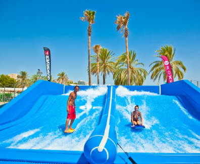 A man and a woman surfing on a flowrider